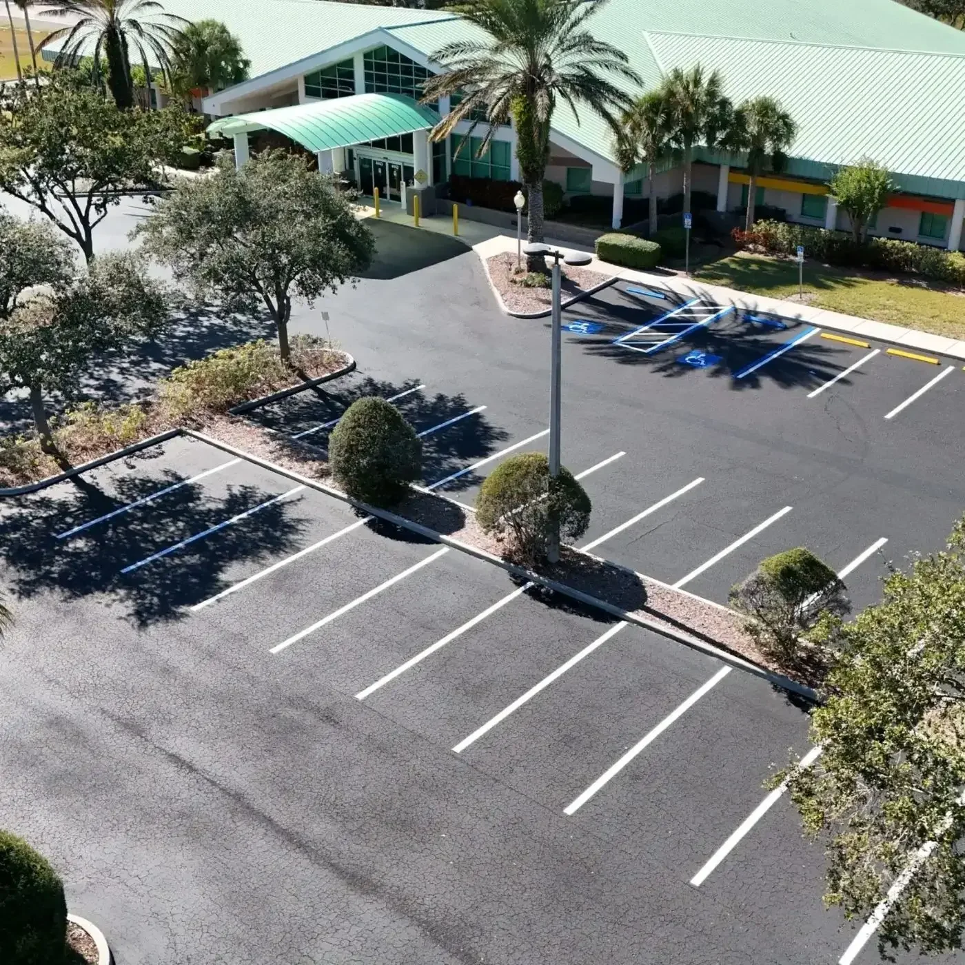 Empty parking lot with green-roofed building.