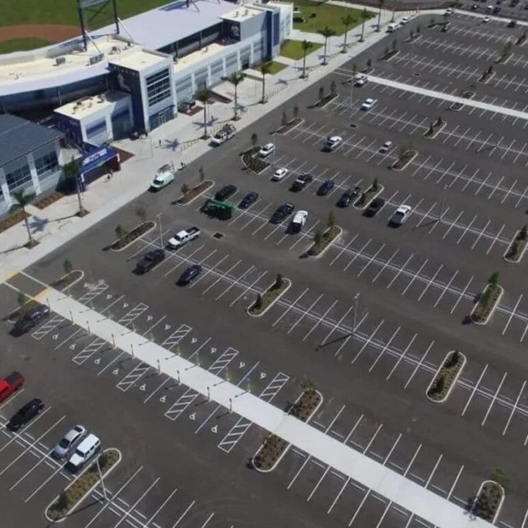 Stadium with large, mostly empty parking lot.